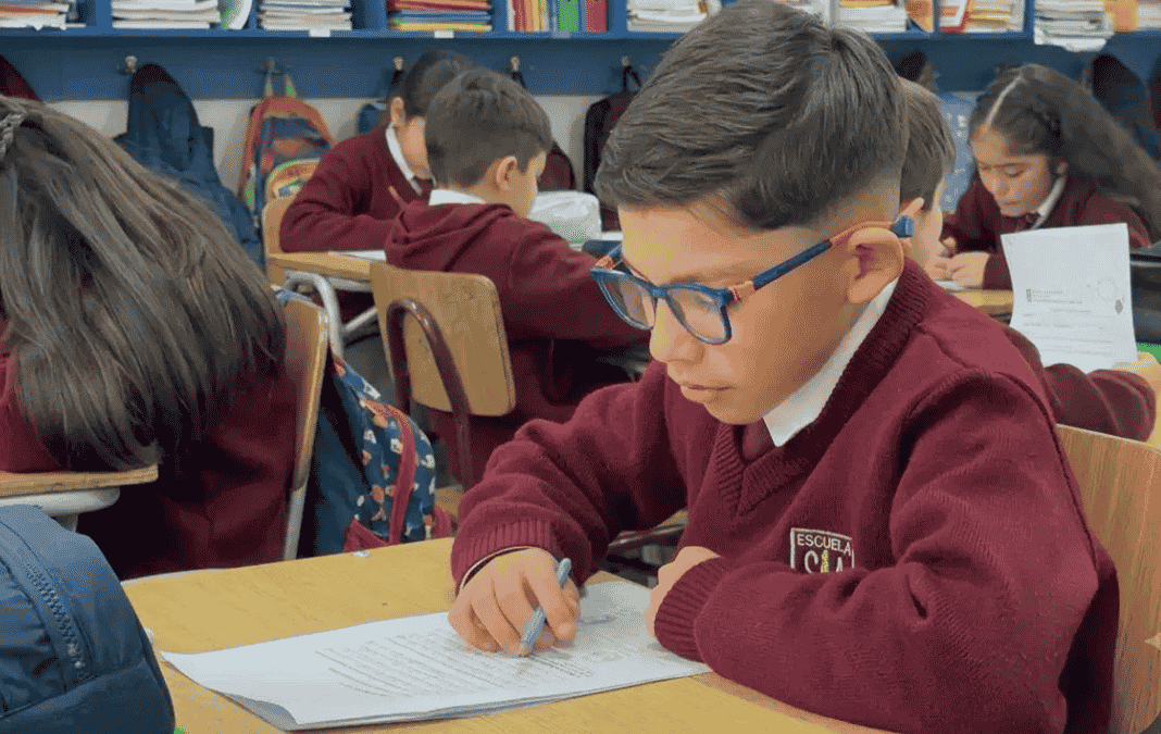 Niña y niño leyendo en una sala de clases