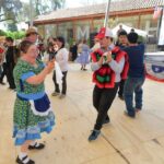 Una mujer y un hombre con síndrome de Down bailando cueca y con vestimenta típica de china y huaso