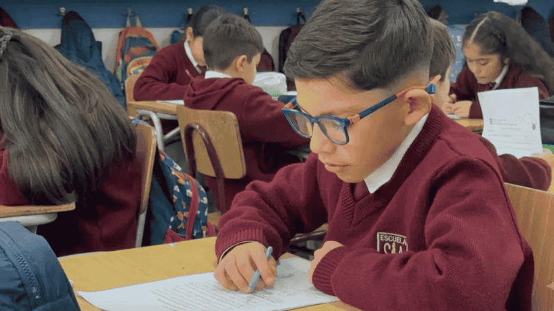 Niña y niño leyendo en una sala de clases