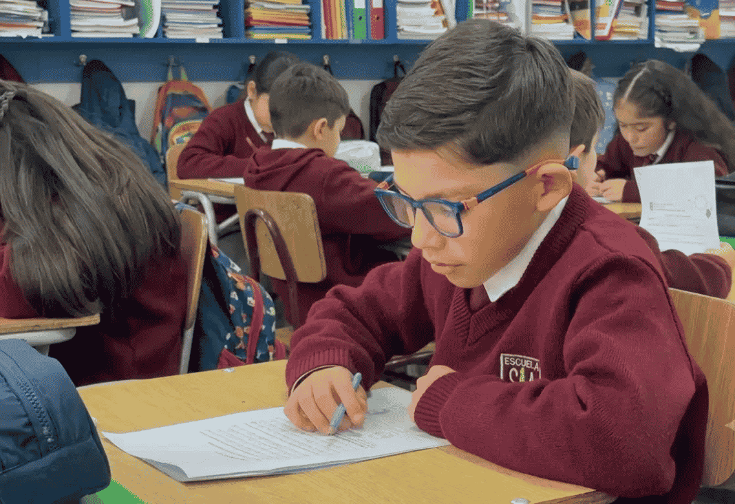 Niña y niño leyendo en una sala de clases