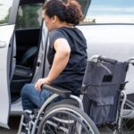 Mujer en silla de ruedas subiendo a un auto