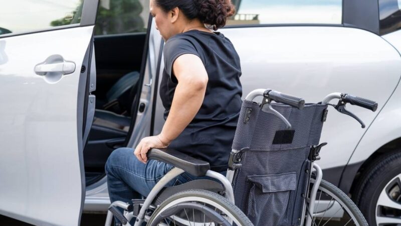 Mujer en silla de ruedas subiendo a un auto