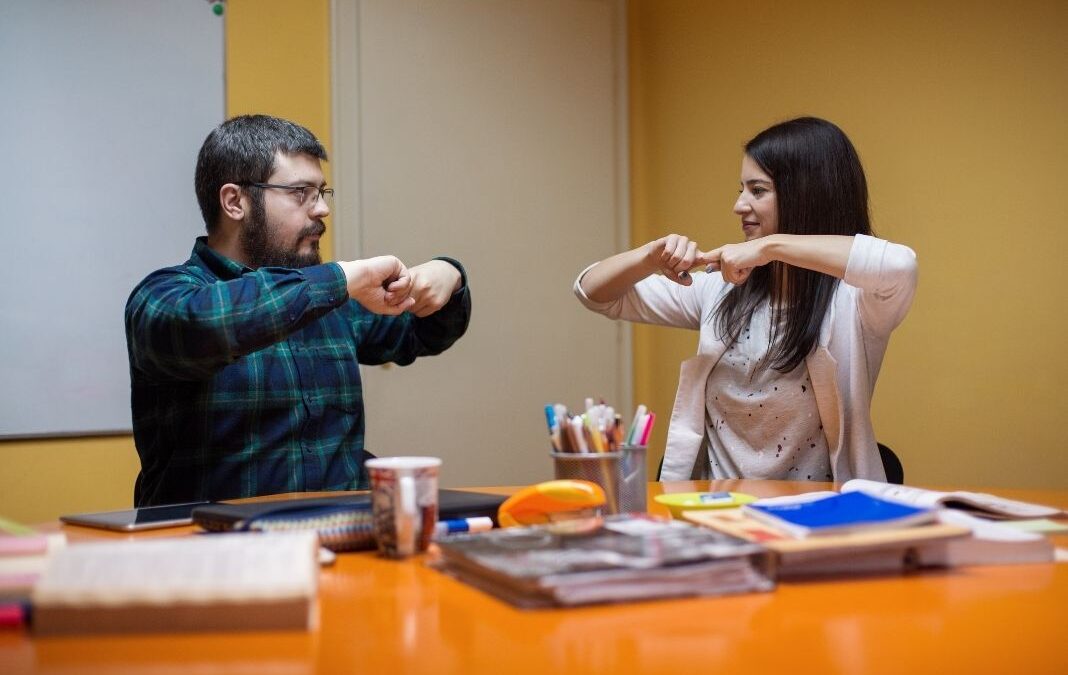 Un hombre y una mujer comunicándose en lengua de señas