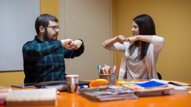 Un hombre y una mujer comunicándose en lengua de señas