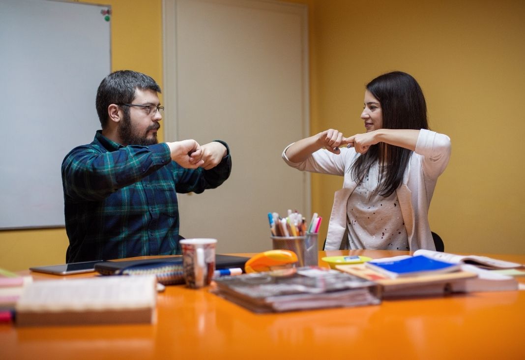 Un hombre y una mujer comunicándose en lengua de señas