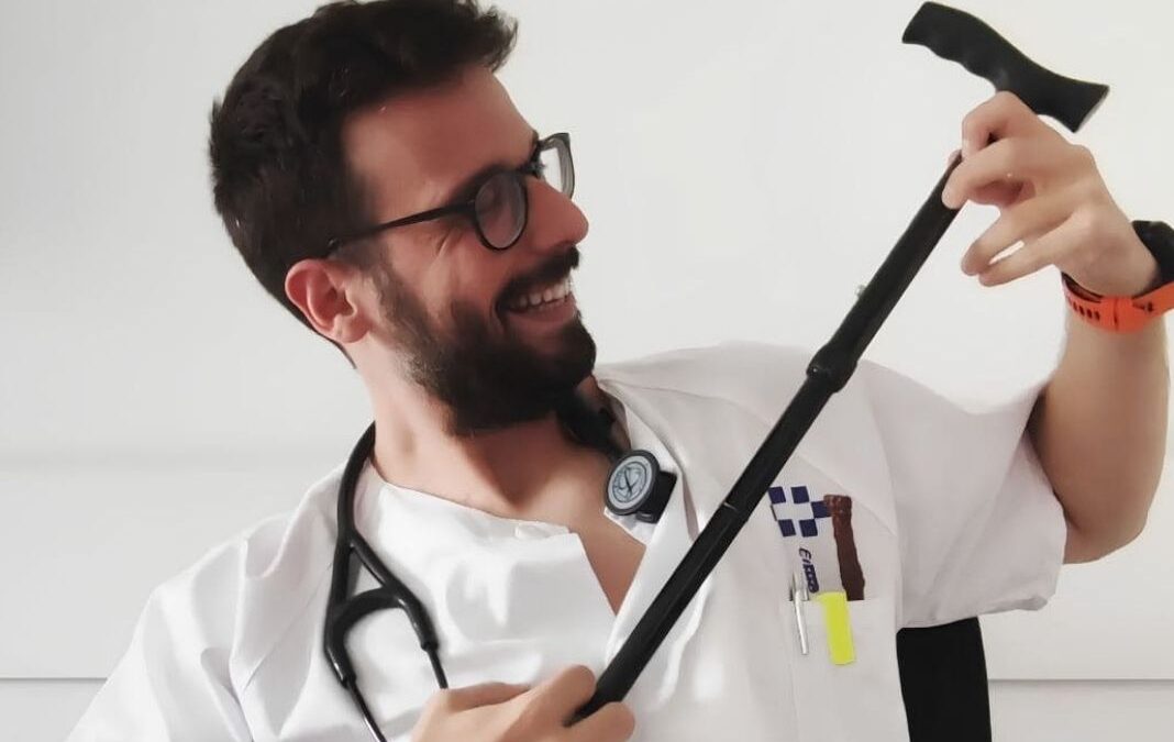 Médico sonriendo y usando un bastón como guitarra