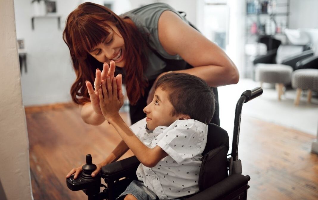 mujer junto a niño con discapacidad física dándose la mano