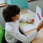 niño leyendo una hoja en una sala de clases