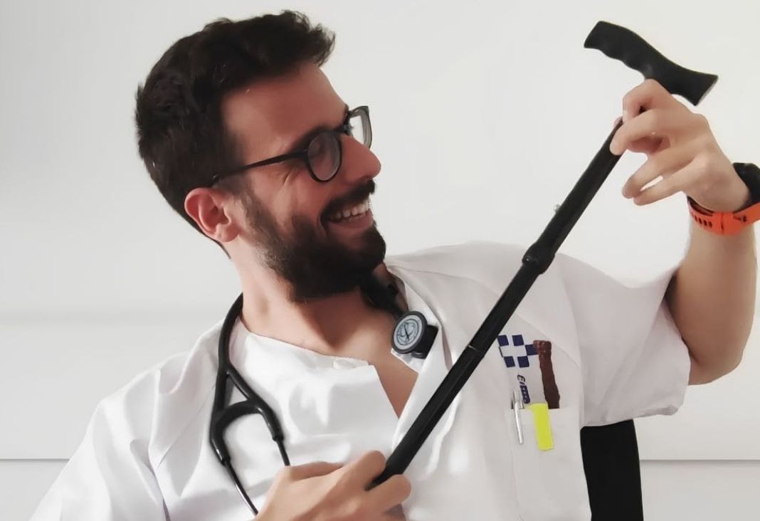 Médico sonriendo y usando un bastón como guitarra
