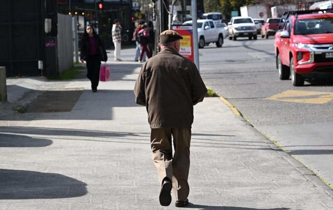Hombre mayor de espalda caminando en la calle