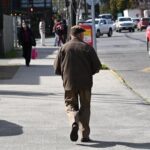 Hombre mayor de espalda caminando en la calle