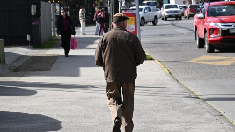 Hombre mayor de espalda caminando en la calle