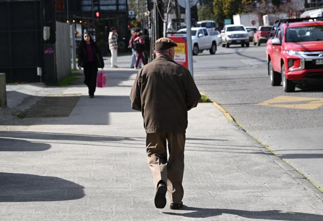 Hombre mayor de espalda caminando en la calle