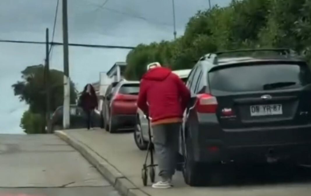 persona mayor de espalda junto a un vehículo