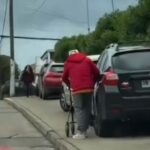 persona mayor de espalda junto a un vehículo