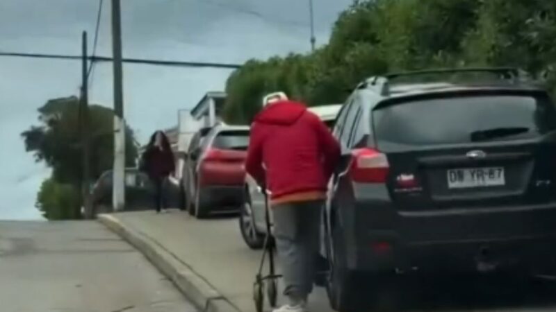 persona mayor de espalda junto a un vehículo