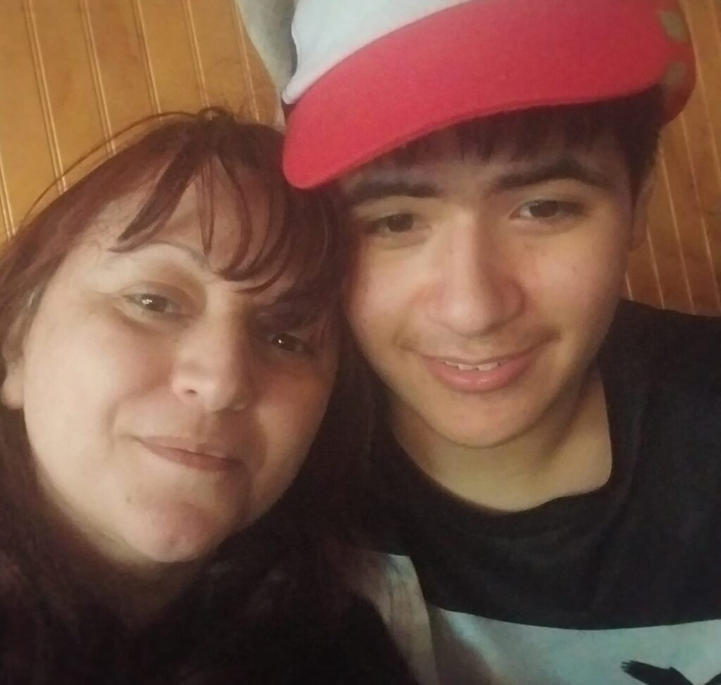 Mujer junto a su hijo, quien lleva un gorro de sol en la cabeza