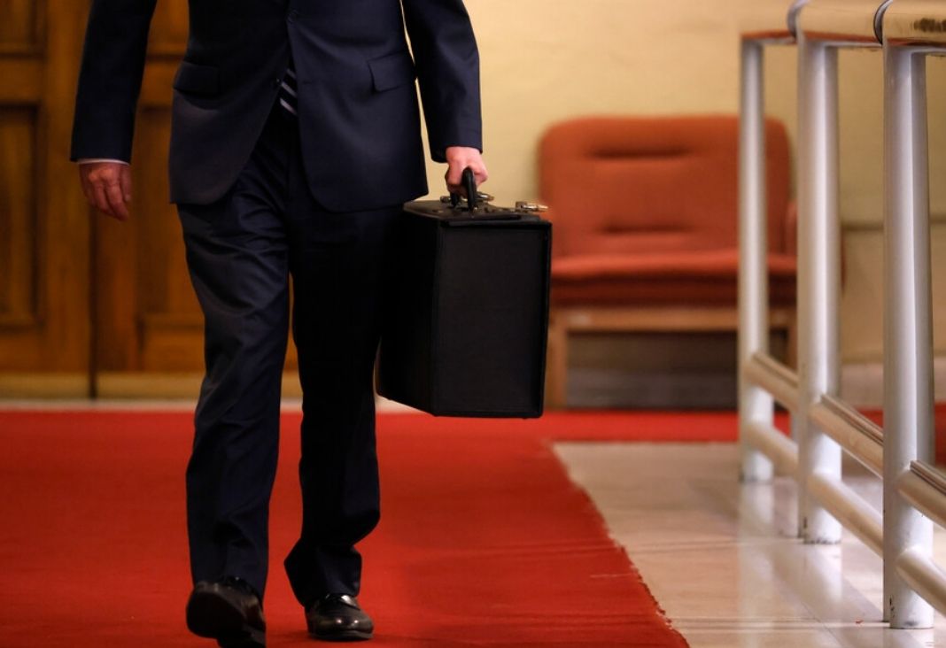 Hombre llevando un maletín en su mano en medio de un pasillo