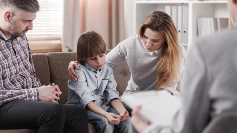 hombre, mujer y un niño en una consulta médica