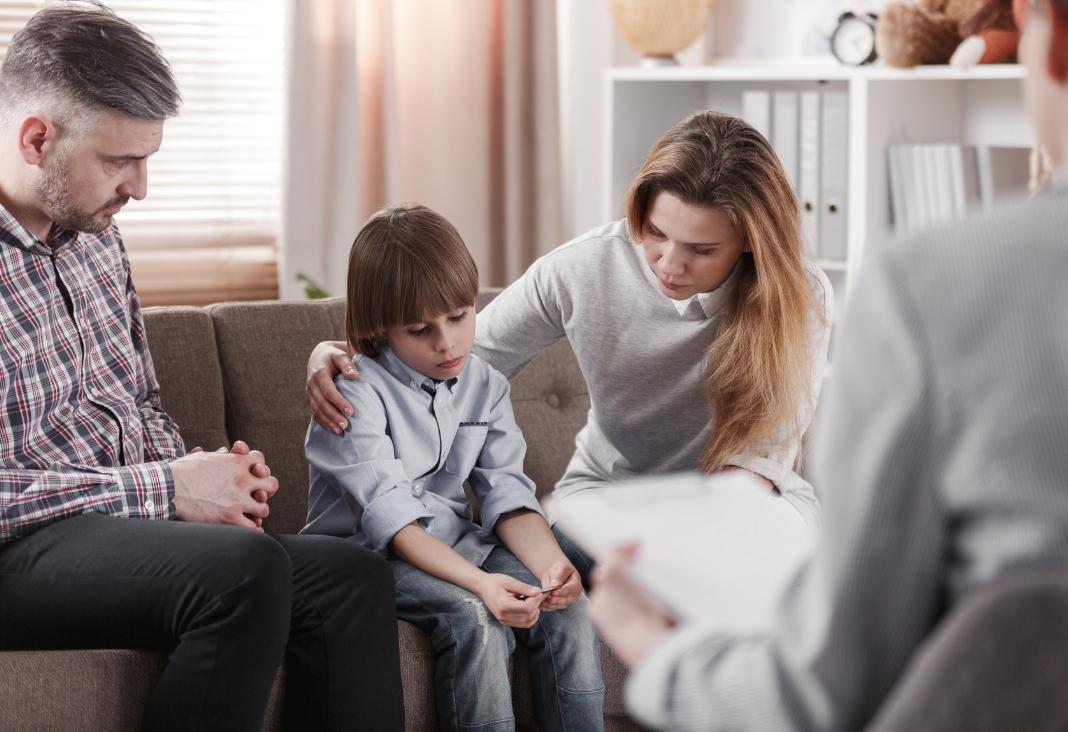 hombre, mujer y un niño en una consulta médica