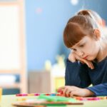 niña jugando triste