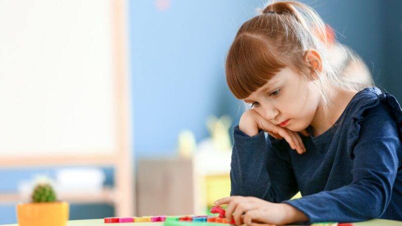 niña jugando triste