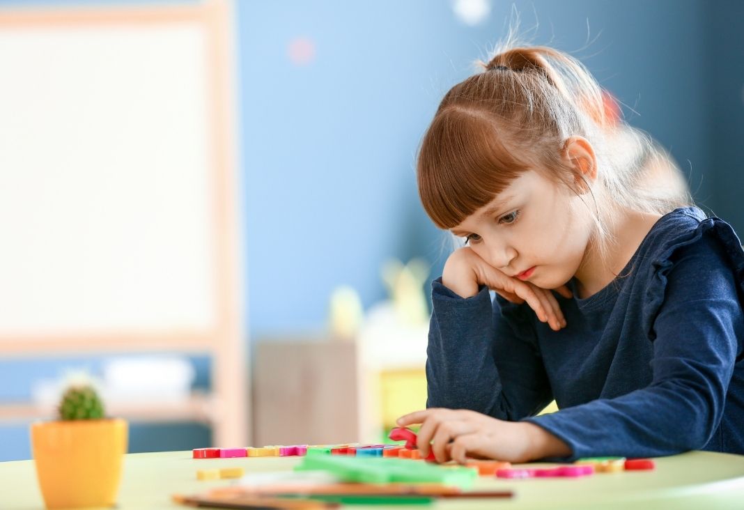 niña jugando triste