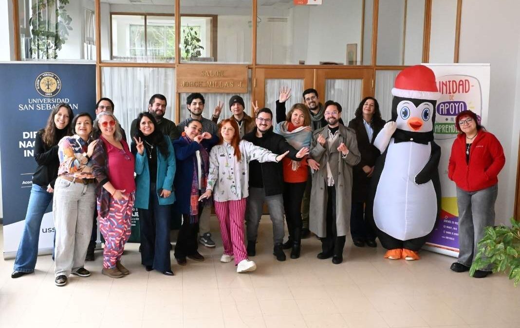 varas personas posando hacia la cámara y un corpóreo de un pinguino
