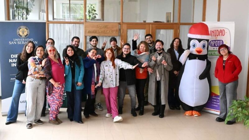 varas personas posando hacia la cámara y un corpóreo de un pinguino