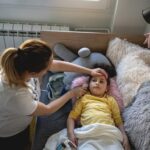 Mujer cuidando a niña enferma acostada en una cama