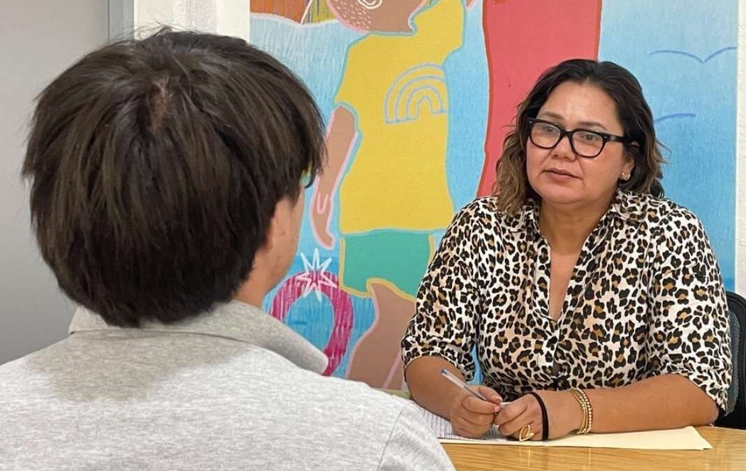 mujer atendiendo a un joven que está de espalda