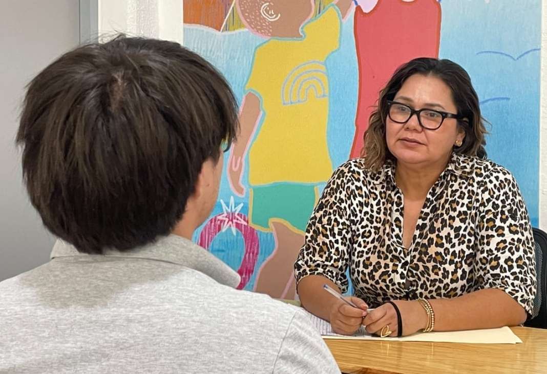 mujer atendiendo a un joven que está de espalda