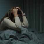 Mujer afligida sentada en una cama