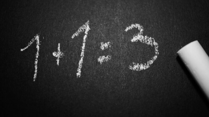 pizarra negra con letras blancas que dice 1+1=3