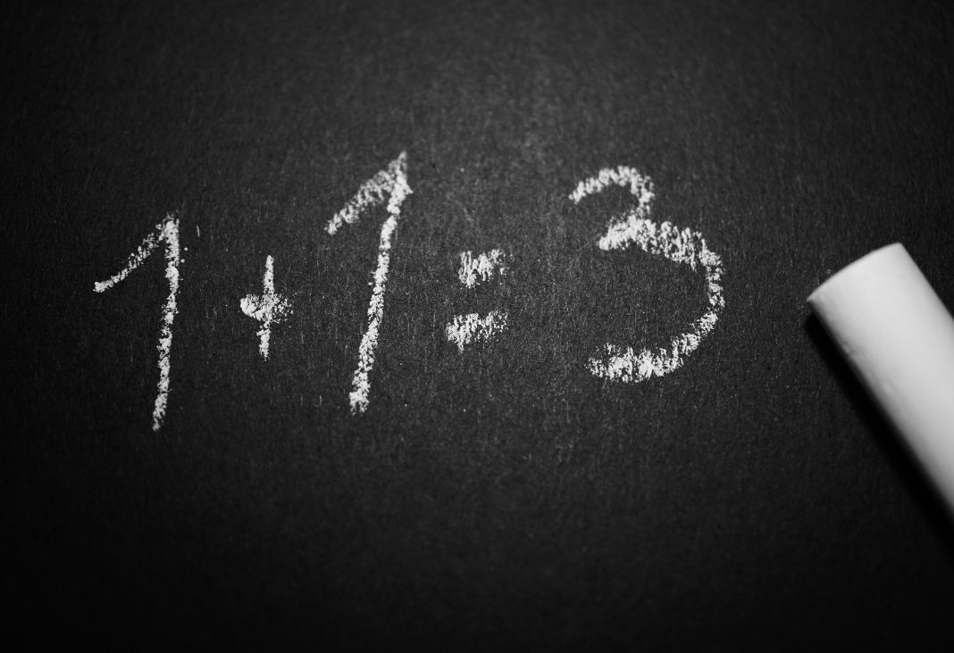 pizarra negra con letras blancas que dice 1+1=3