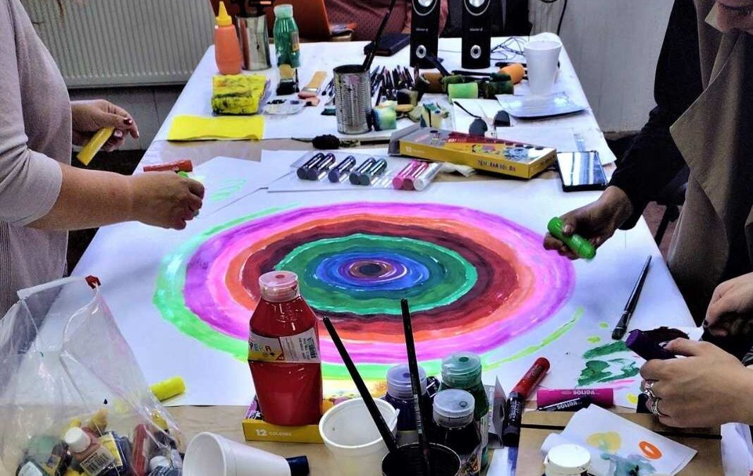 Varios materiales para pintar y una pintura de círculo con varios colores