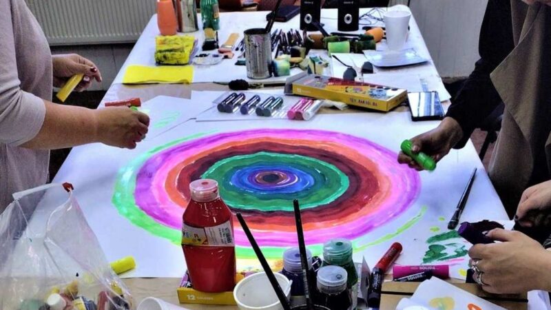 Varios materiales para pintar y una pintura de círculo con varios colores