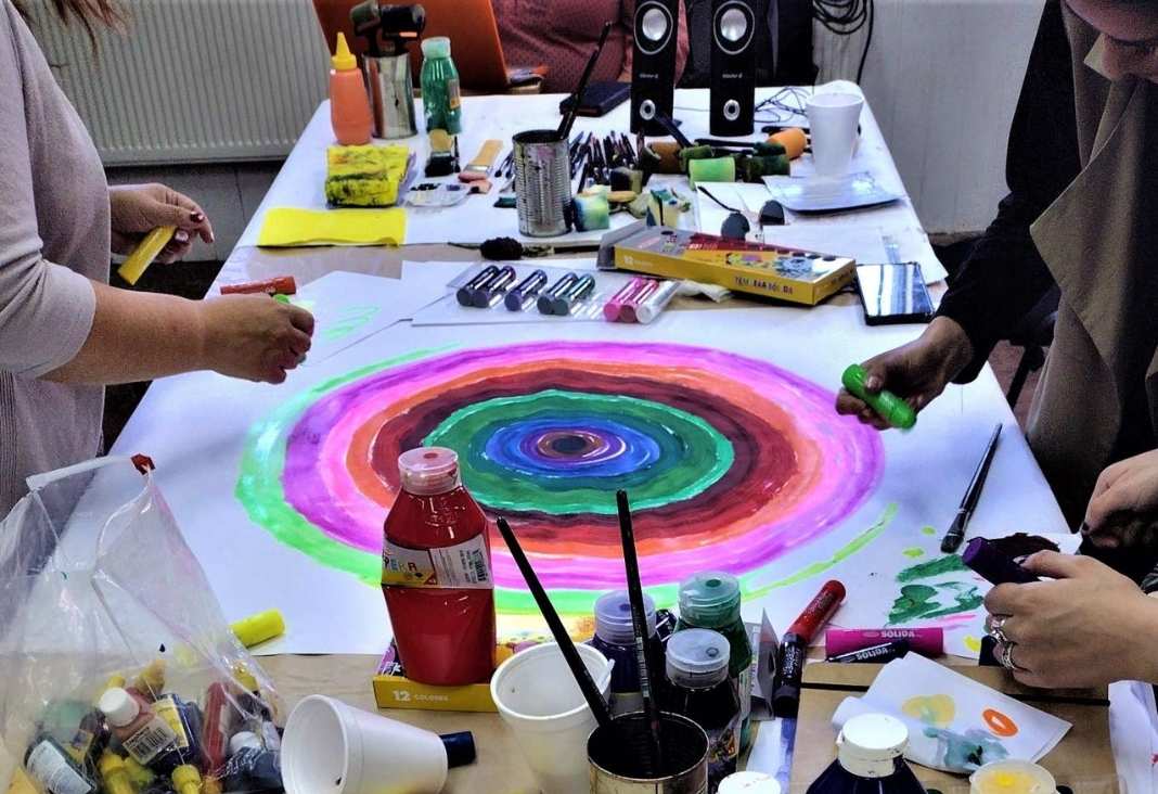 Varios materiales para pintar y una pintura de círculo con varios colores